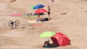 Gente tomando el sol en la playa del Miracle, en Tarragona.
