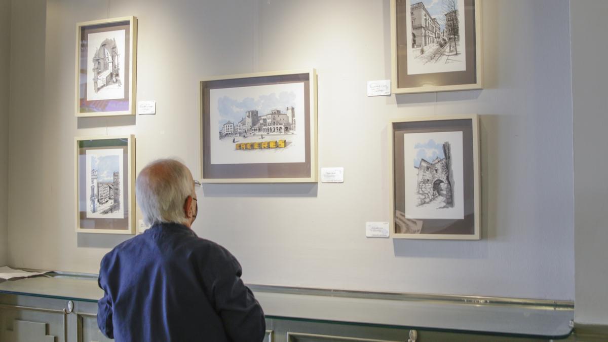 Un cacereño admira la muestra de &#039;Cáceres in blue&#039; en el Gran Café.