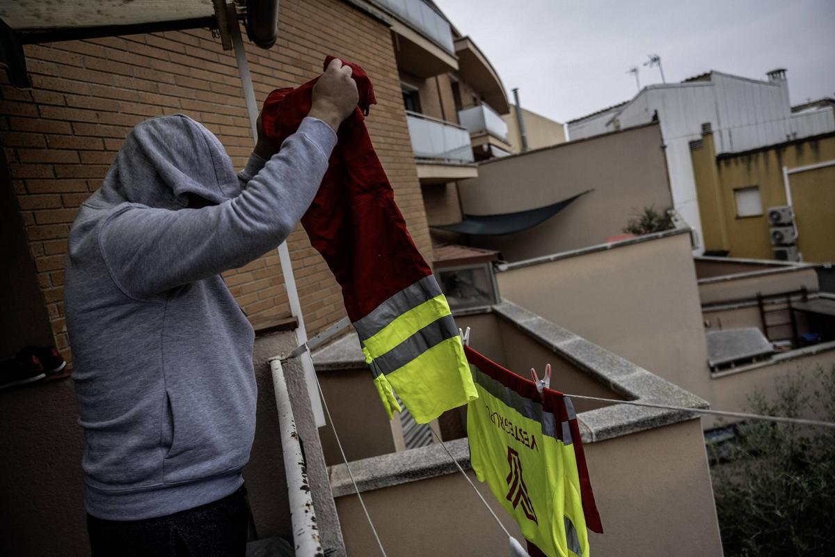 Mohamed, empleado en el Grupo Yeste, tiende la ropa del trabajo.