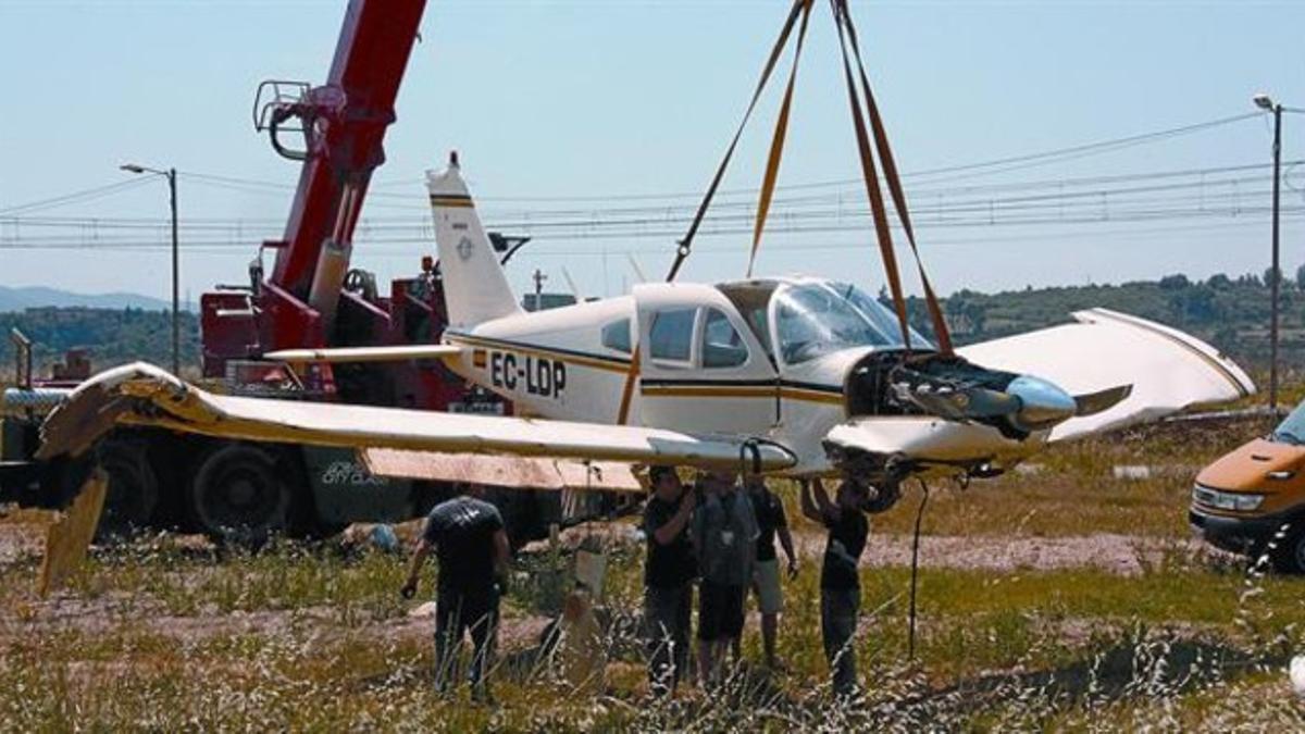 Una grúa levanta la avioneta accidentada, ayer en el parque Central del Vallès.