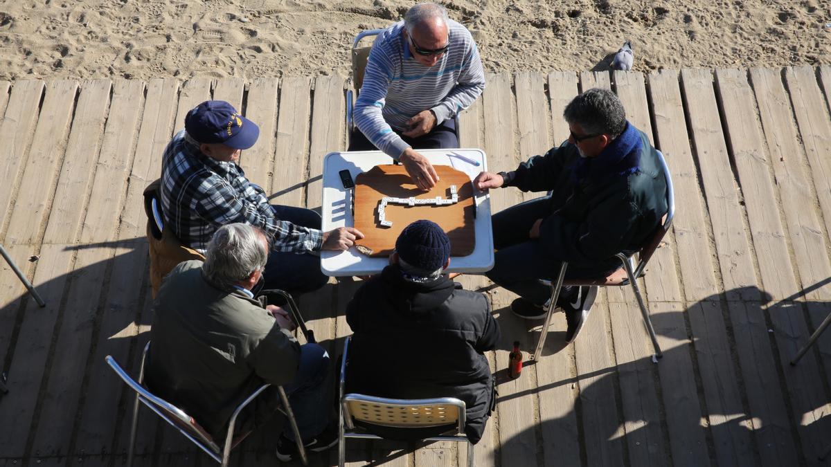 Un grupo de pensionistas disfrutan de su retiro en una playa de la costa española.
