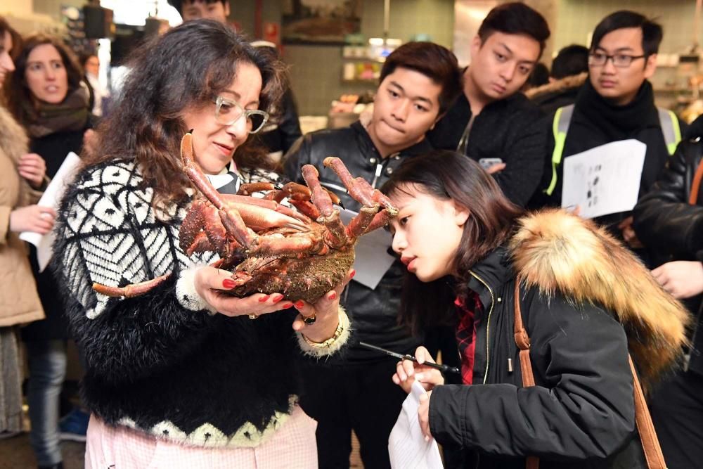 Una treintena de alumnos del Centro de Linguas de la Universidad coruñesa procedentes de China y Vietnam visitan el mercado de la plaza de Lugo para aprender argot gastrónomico gallego.