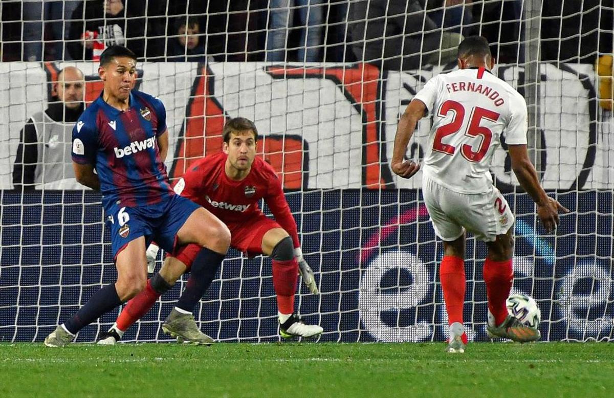 El jugador del Sevilla Fernando remata ante Aitor Fernández.