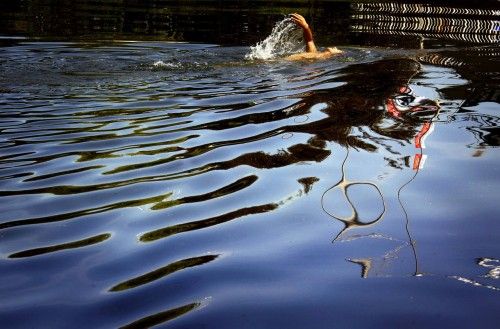 A man swims in a polluted canal in central Beijing