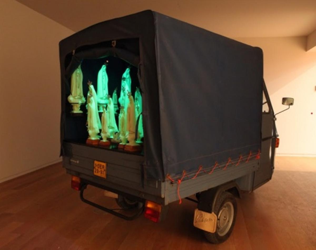 Obra de Vasconcelos de una Piaggio APE50 con estatuillas de Nuestra Señora de Fátima fosforescentes
