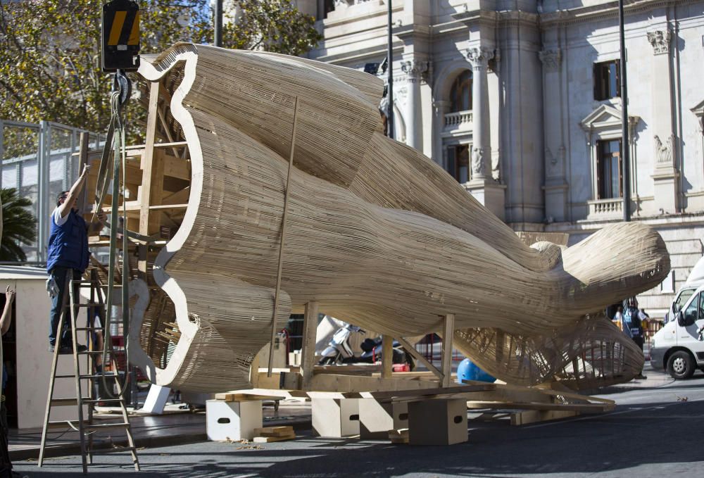 Los trabajadores del taller del artista fallero Manolo García preparan el izado de una de las piezas de la Falla de la Plaza del Ayuntamiento.