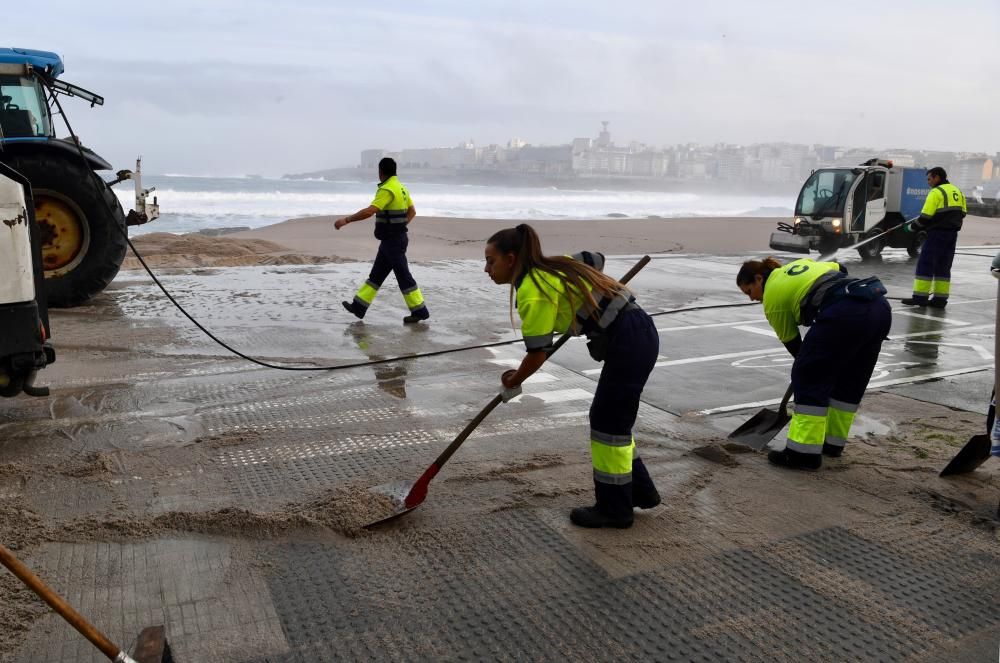 El mar empuja arena al paseo, cortado al tráfico