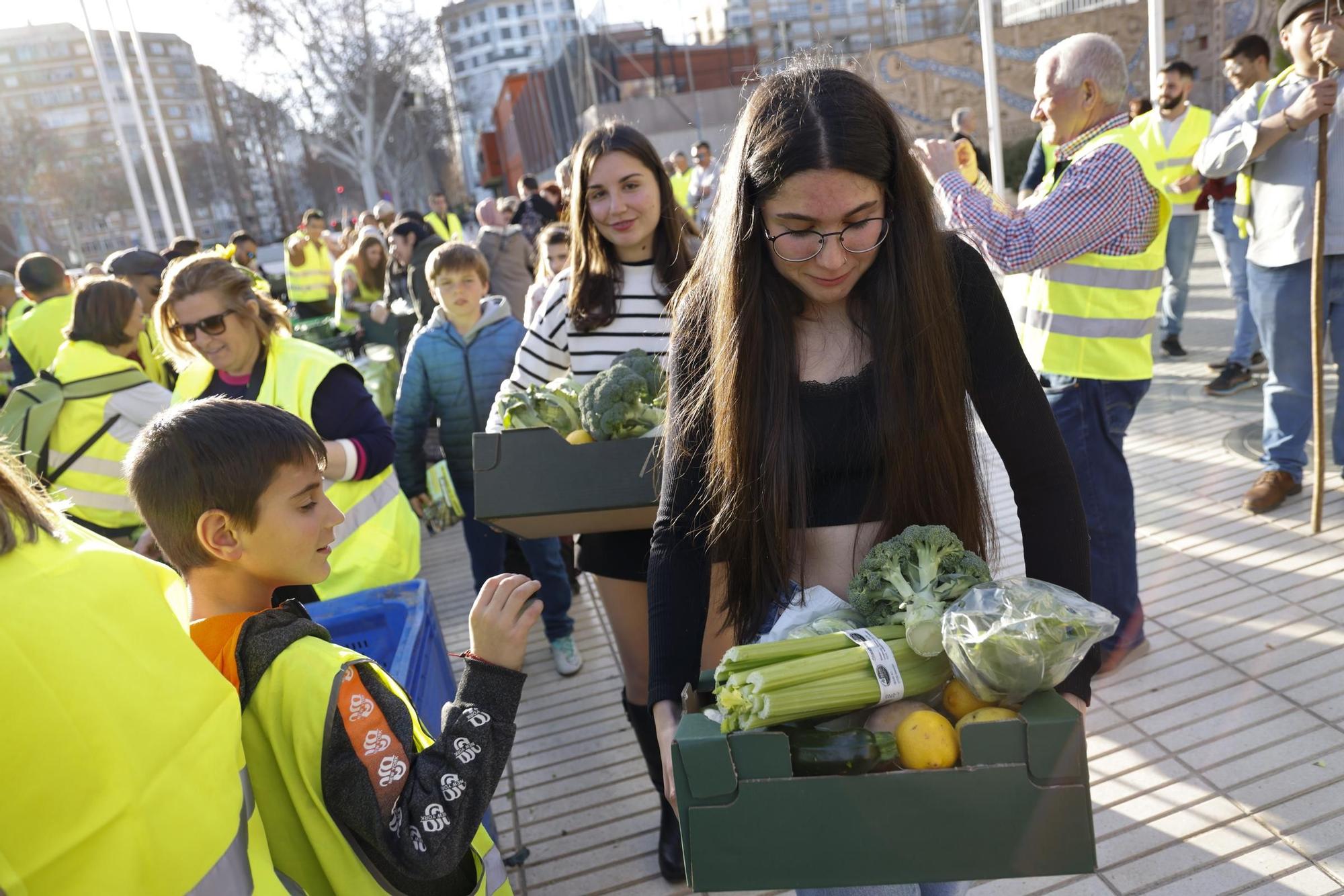 Las imágenes del plante de los agricultores frente a la Asamblea, donde han repartido frutas y hortalizas