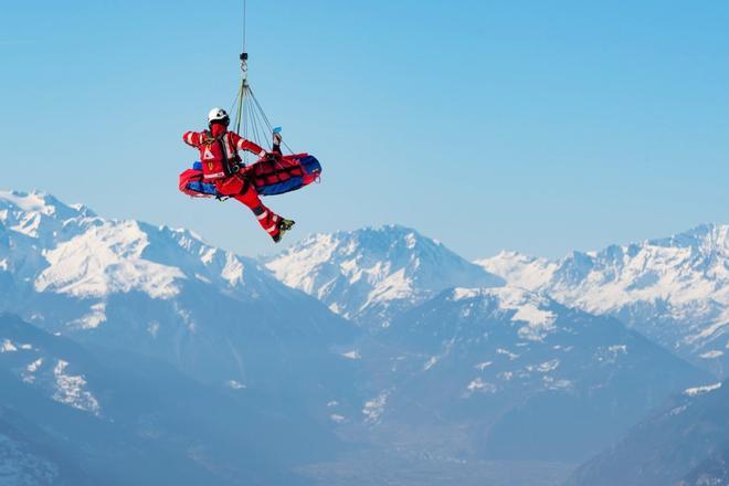 Un helicóptero de la compañía Air Zermatt traslada al esquiador Meike Pfister durante el entrenamiento del descenso femenino de la Copa del mundo de esquí alpino, este jueves en Crans-Montana, Suiza.
