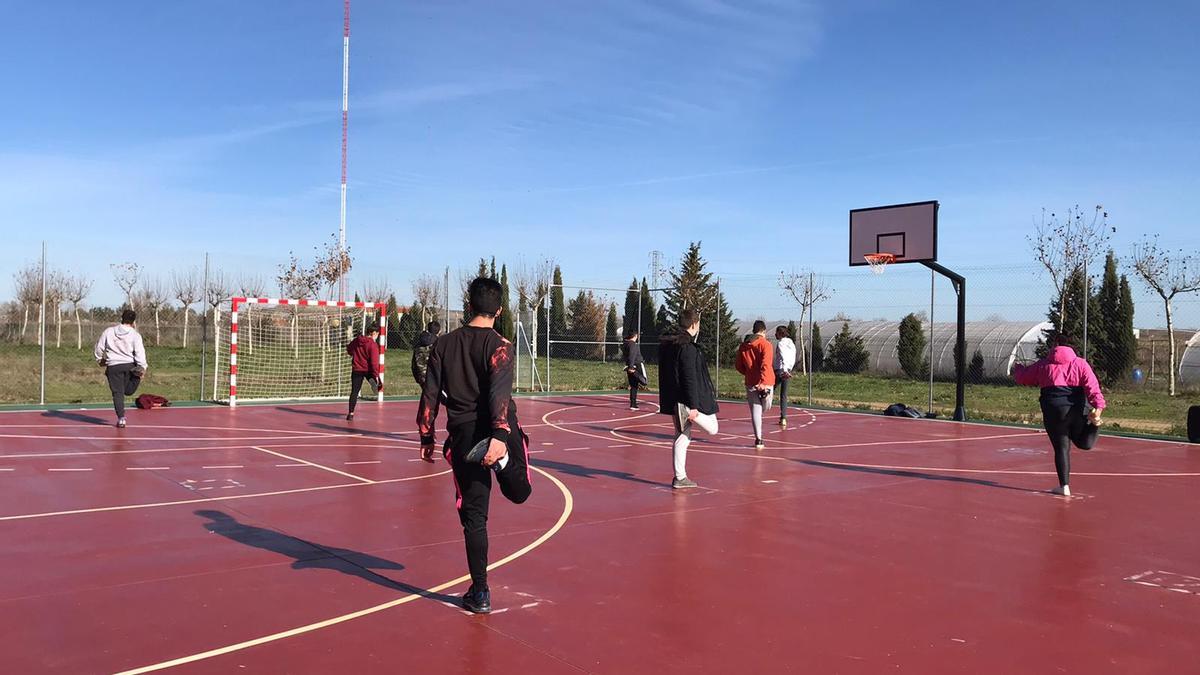 Un grupo de alumnos, en una clase de educación física en el patio de un centro.