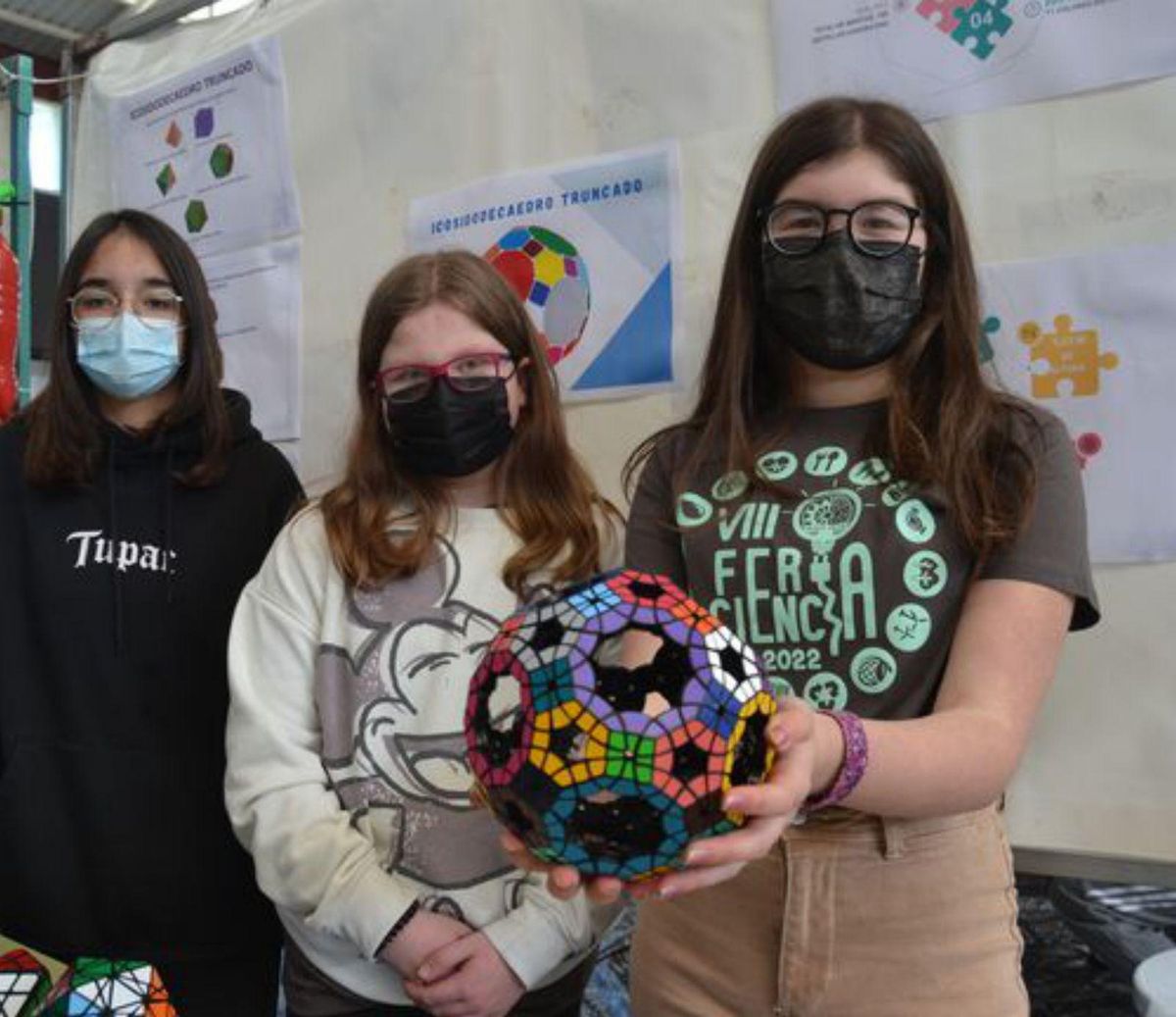 Por la izquierda, Ariam Fernández y María Iglesias, con el cubo geométrico que da la bienvenida a la feria. | A. M. S.