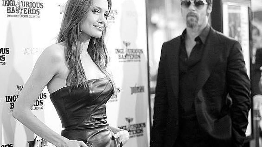 Brad Pitt observa a Angelina Jolie posando en solitario ante la prensa en Hollywood, el pasado día 11.