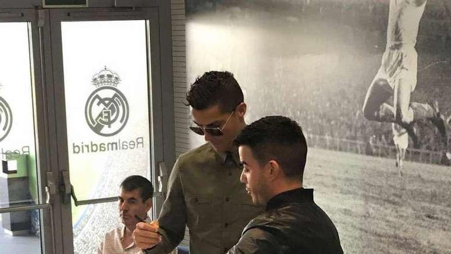 Cristiano firma el banderín con el que obsequió a Marcos Torres.