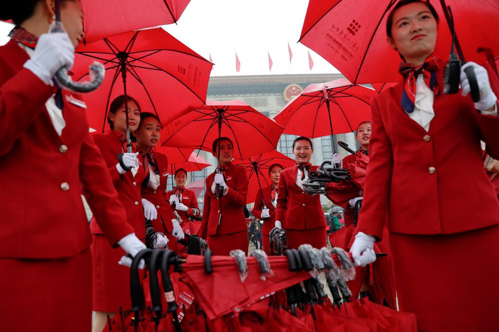 Ushers manage umbrellas used by delegates...