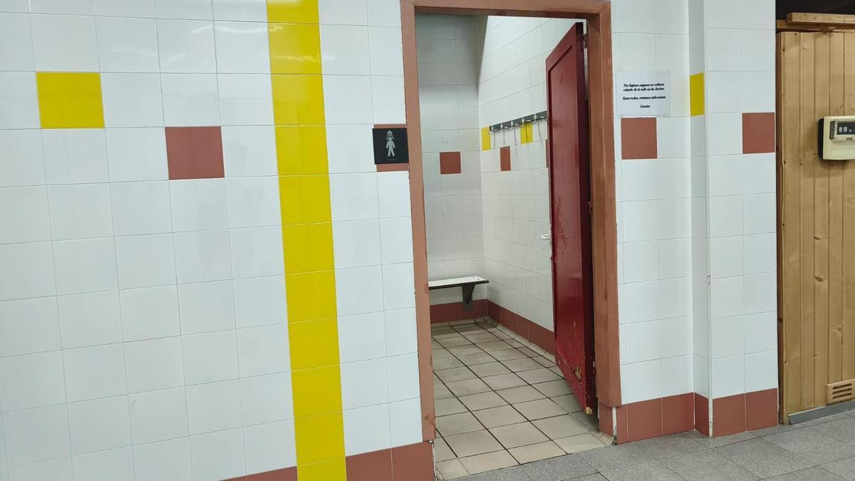 Acceso a la zona de duchas de la piscina de Los Almendros, una vez levantado el precinto por legionela.