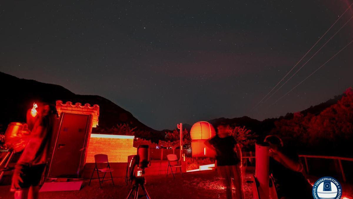 Diverses persones observant amb telescopis el cel fosc d'Albanyà