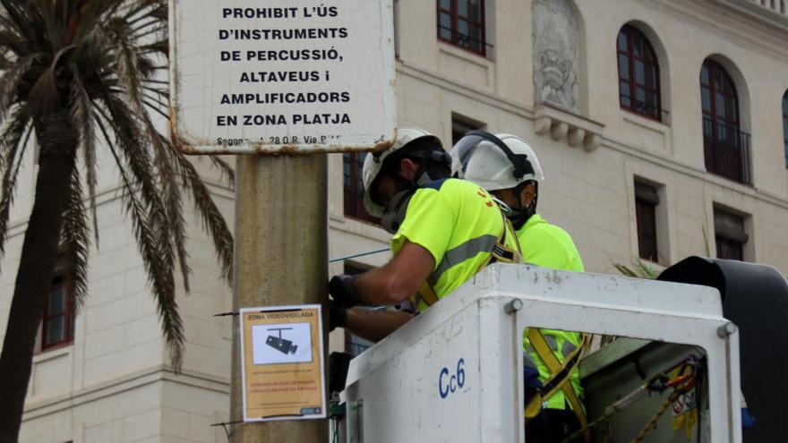 Operaris instal·lant les càmeres a la platja de Barcelona