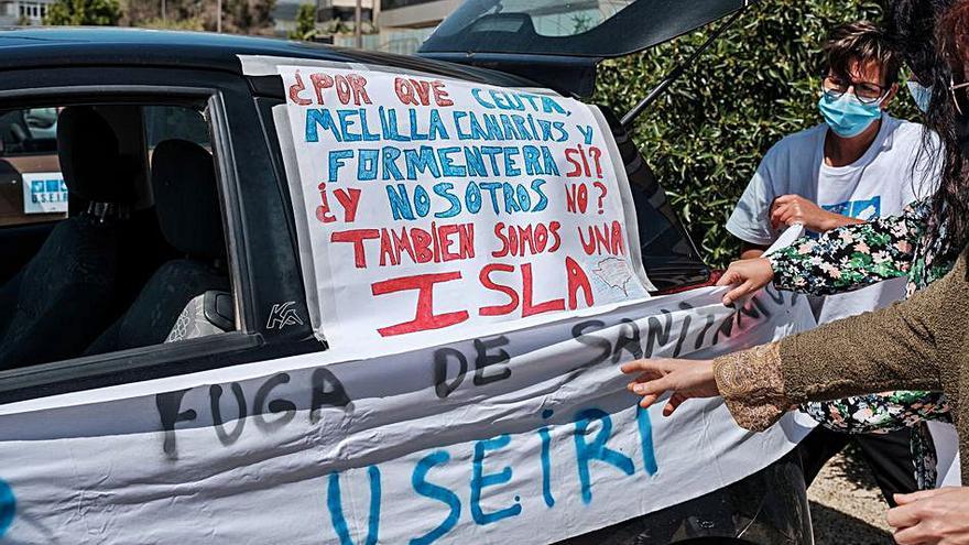 Integrantes de Useiri tratan de pegar una pancarta al lateral de un coche antes de la protesta.