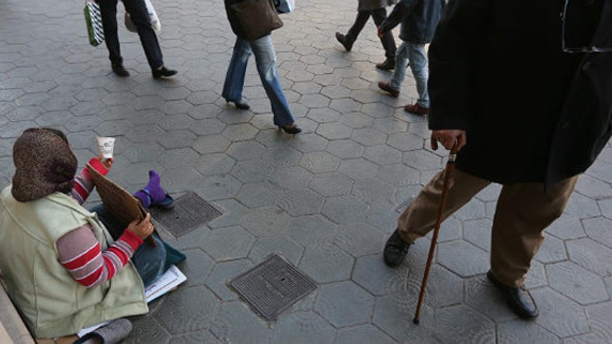 Una mujer pide limosna en Barcelona.