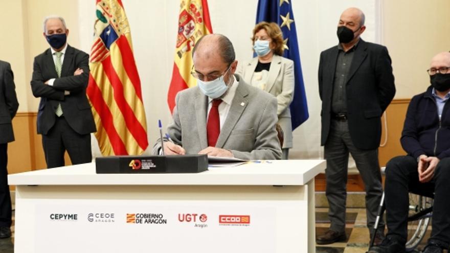 Javier Lambán firma el documento que sella el acuerdo con los agentes sociales.