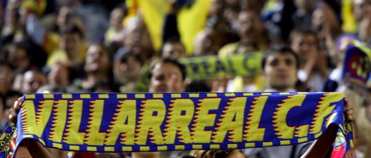 Una aficionada muestra con orgullo su bufanda del Villarreal animando a su equipo