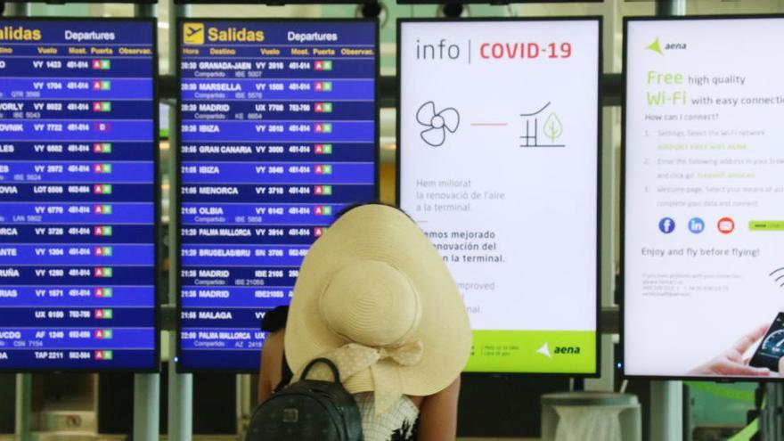 Una viatgera consultant les pantalles informatives a l&#039;Aeroport del Prat