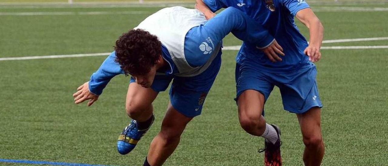 Miki trata de disputarle un balón a Tomás durante un entrenamiento celebrado en Príncipe Felipe. // Rafa Vázquez