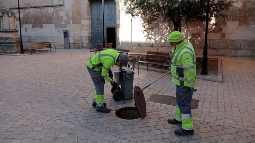 Dos operarios trabajan en una alcantarilla.