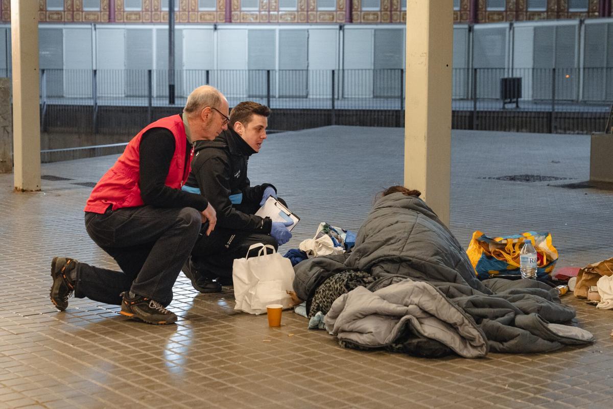 Miembros de la Cruz Roja y los Servicios Sociales de Barcelona atienden a una persona durante la Operación Frío.