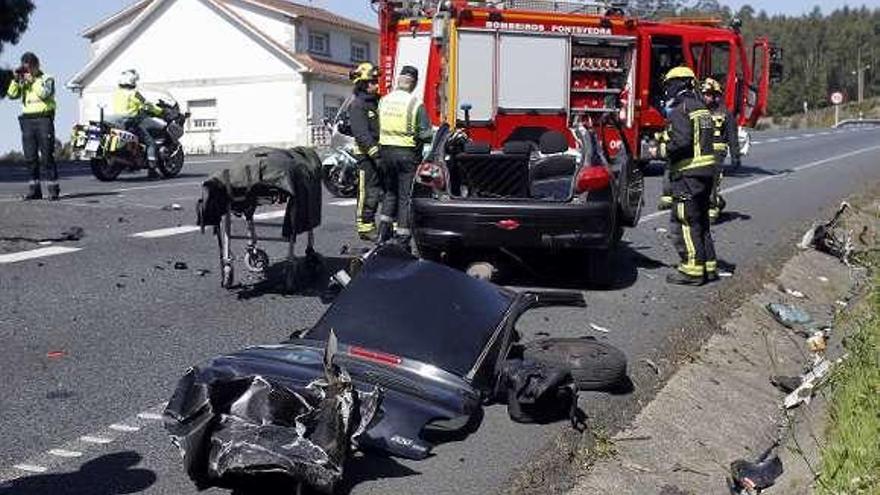 Guardia Civil y bomberos ante los restos del coche destrozado. // R.V.