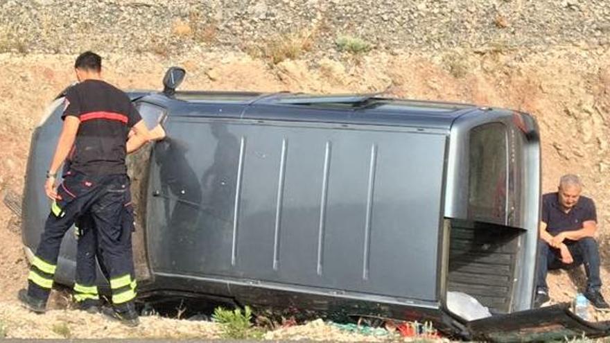 El conductor y un bombero junto al vehículo tras el siniestro