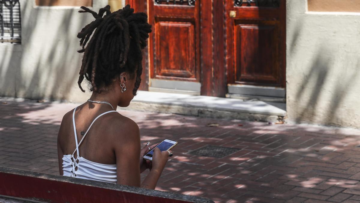 Una joven usa Instagram en las calles de Valencia.