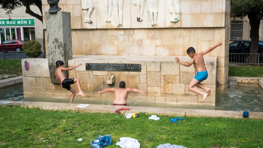 Uns nens banyant-se a la font de la plaça Tarradellas.