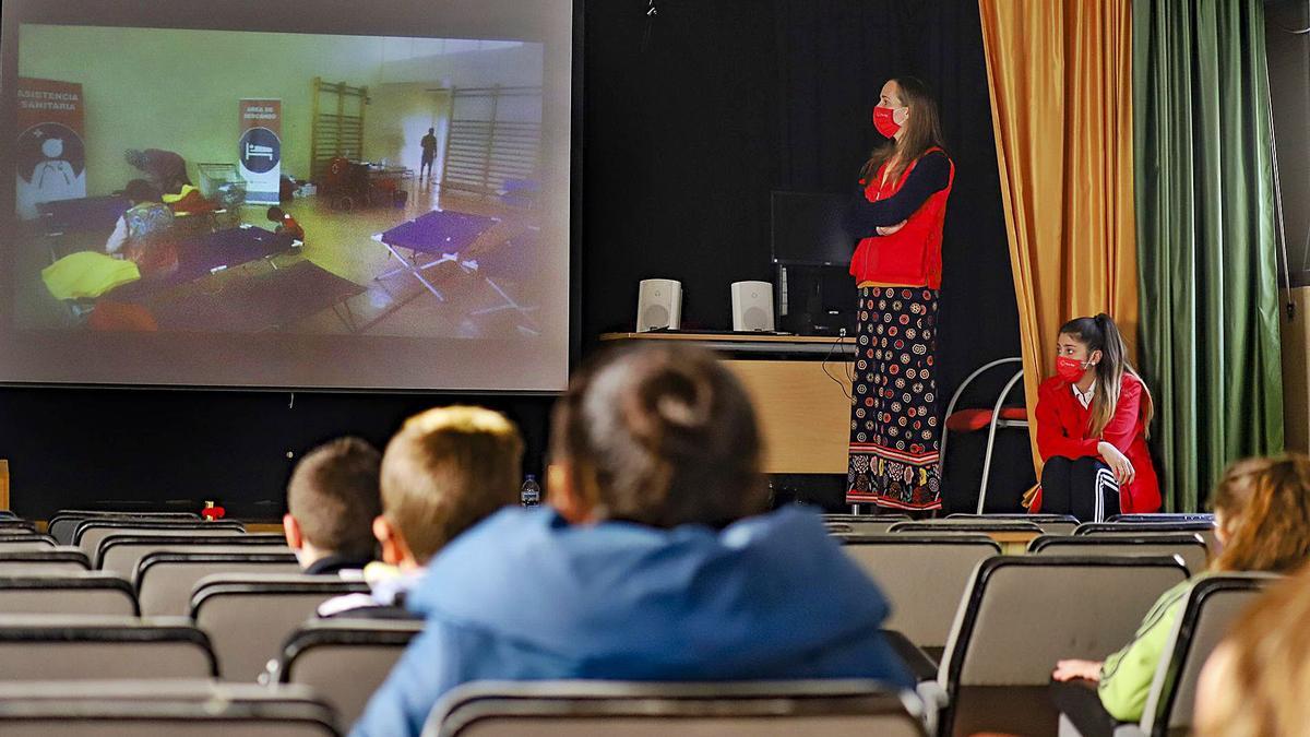 Escolares del colegio Rafael Altamira de Callosa miran atentos el vídeo con la intervención de Cruz Roja durante la DANA.