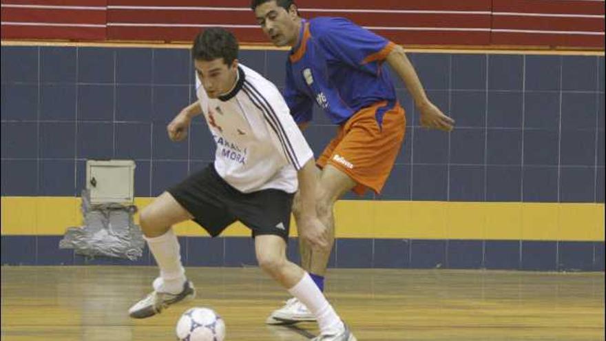 Un jugador del Salud Dental controla el balón ante un rival