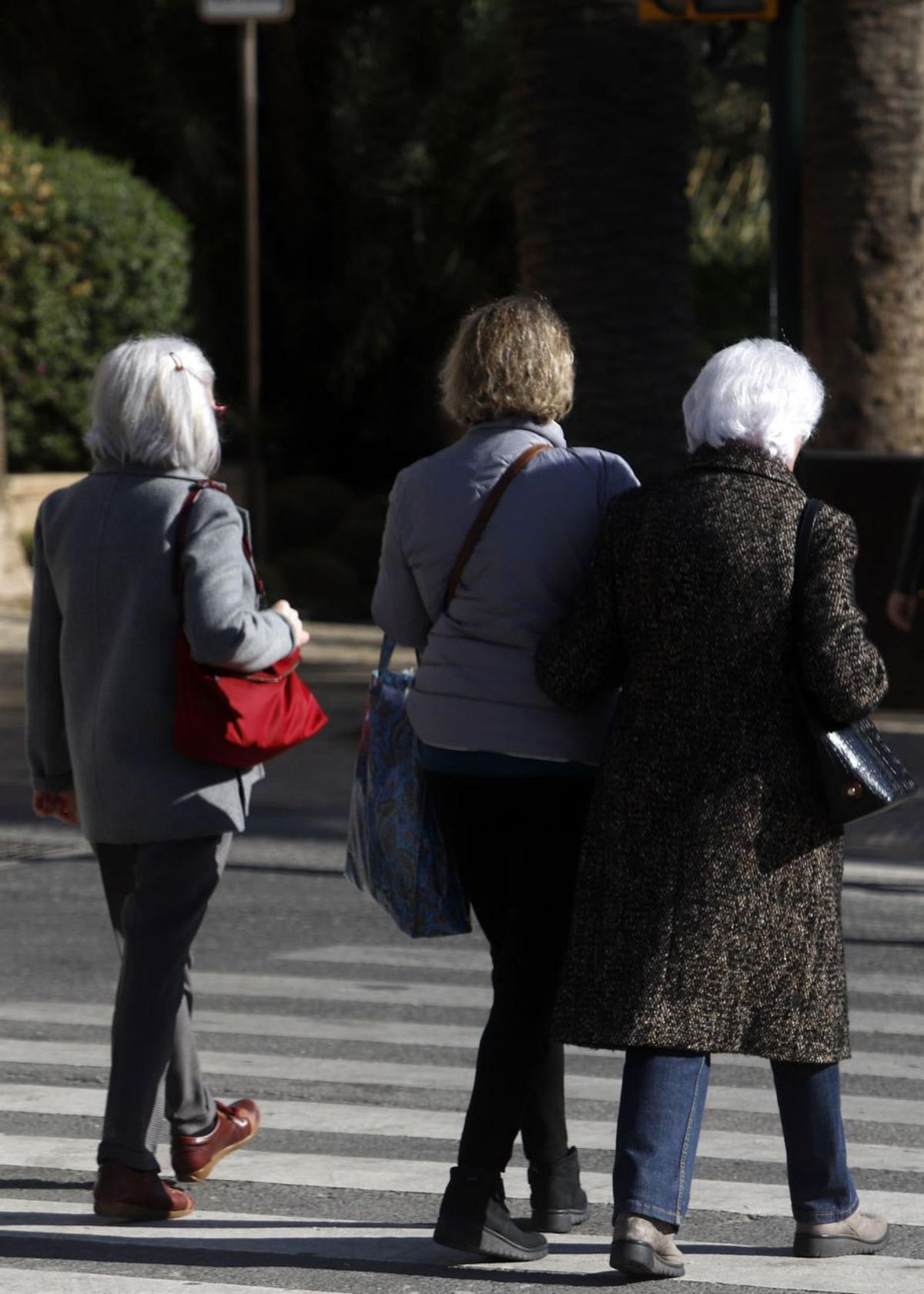 Personas mayores pasean por la calle en Málaga.