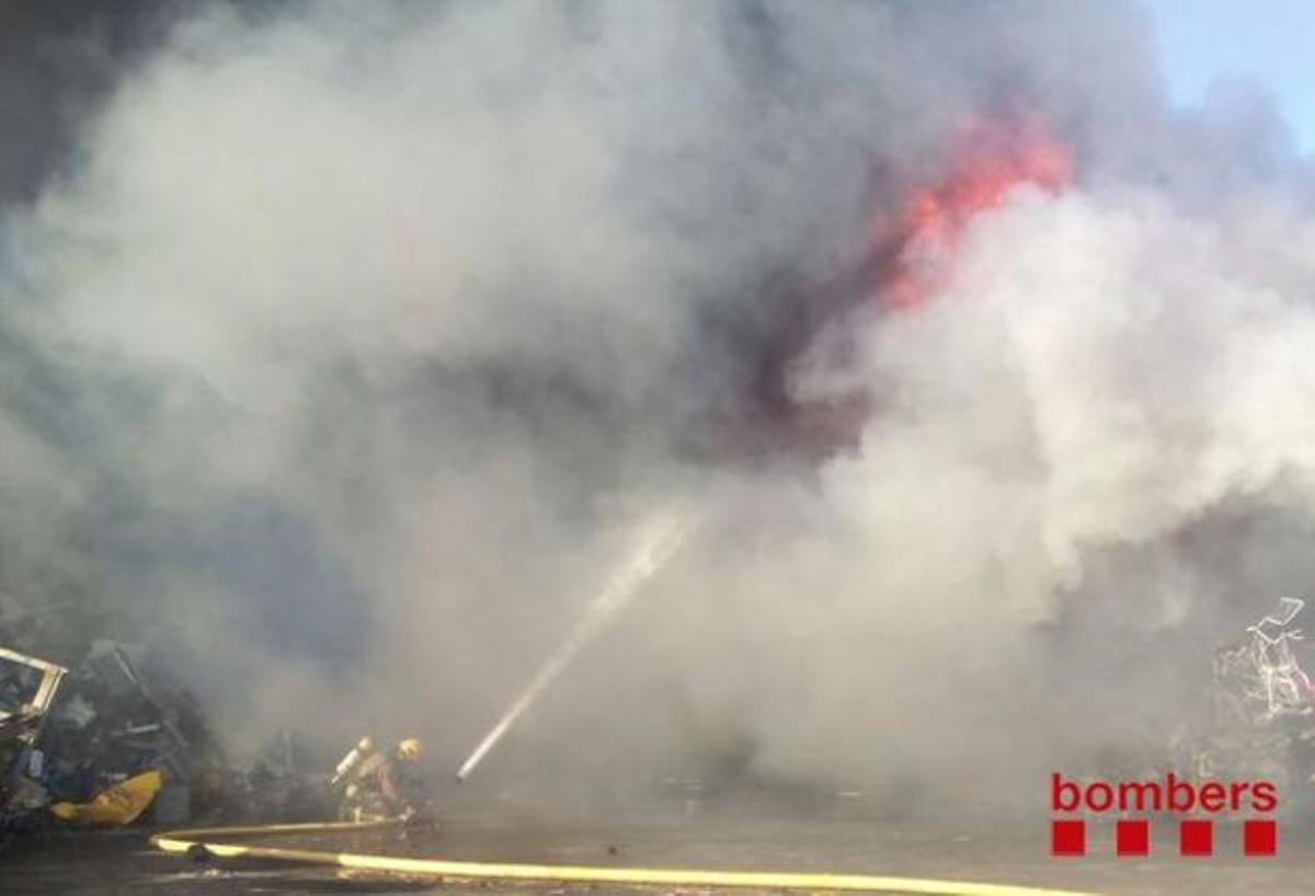 Vint dotacions de bombers treballen per controlar l’incendi a l’empresa de desballestament de vehicles.