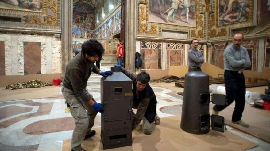 Trabajadores preparan las dos chimeneas de la fumata en la Capilla Sixtina para el cónclave.  // Efe