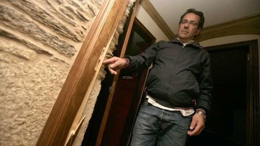 José Luis Barreiro, mostrando los destrozos en la puerta que reventaron los asaltantes. // Bernabé / Cris M.V.