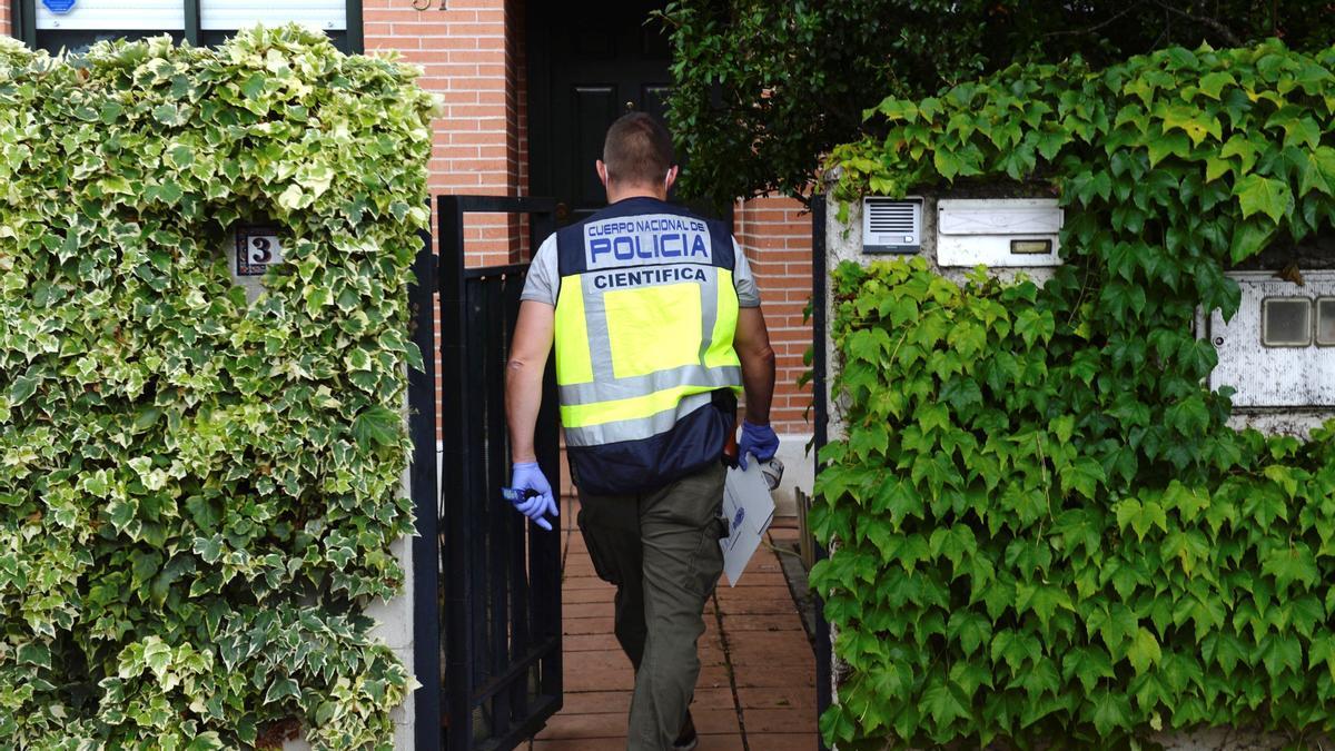 Un miembro de la Policía Científica en la vivienda de Valladolid donde la mujer fue asesinada.