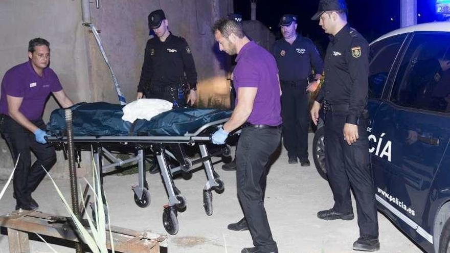 Miembros de los servicios funerarios trasladan el cuerpo del fallecido.