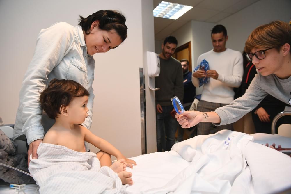 Dos futbolistas del primer equipo -David Simón y Eneko Bóveda-, junto a tres jugadoras del Deportivo Abanca -Cris, Laura y Miriam- visitam a los niños hospitalizados.