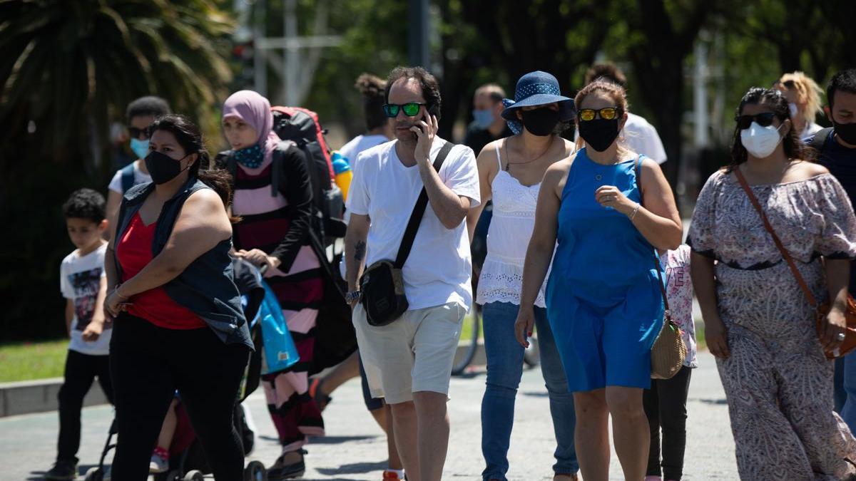 Un grupo de personas pasea por Sevilla, algunos con y otros sin mascarillas.