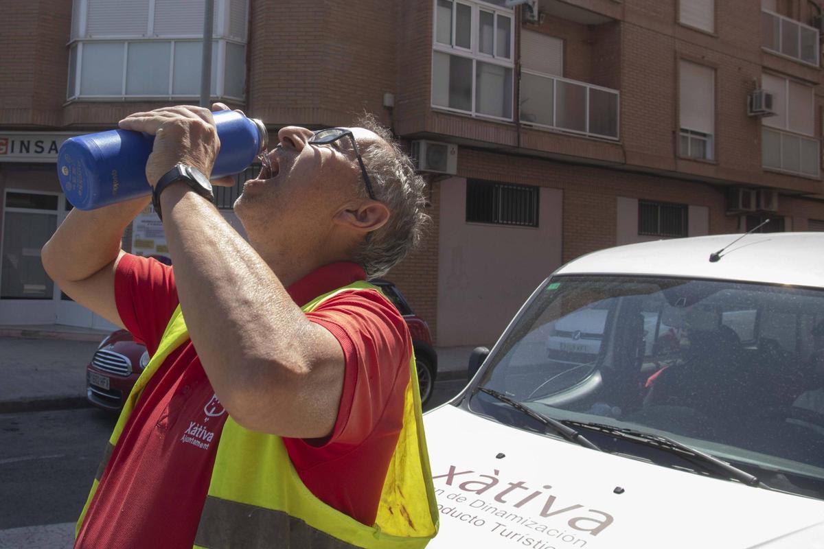 Un trabajador municipal de Xàtiva hidratándose ante las elevadas temperturas registradas este viernes en la capital de la Costera.
