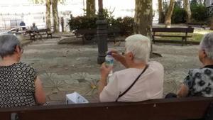 Personas mayores buscando refugio a la sombra en el parque de A Ponte, en plena ola de calor en Ourense.