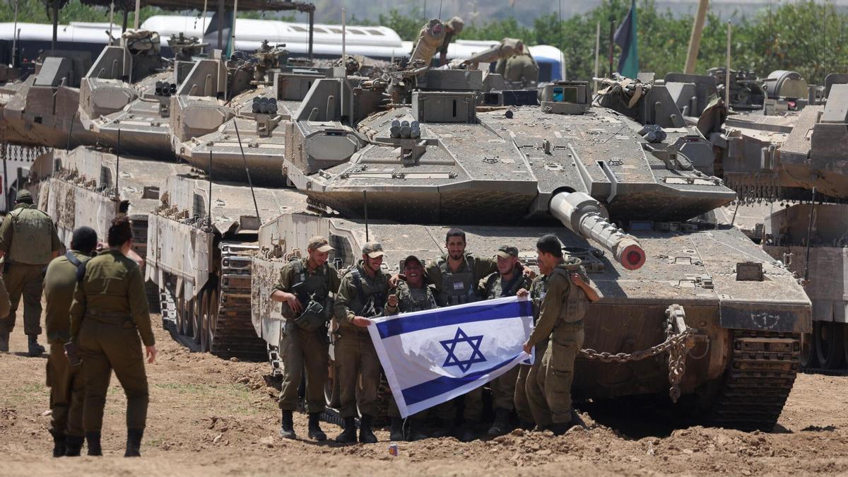 Soldados israelíes posan ante uno de sus tanques a la espera de entrar en Rafah en 2024