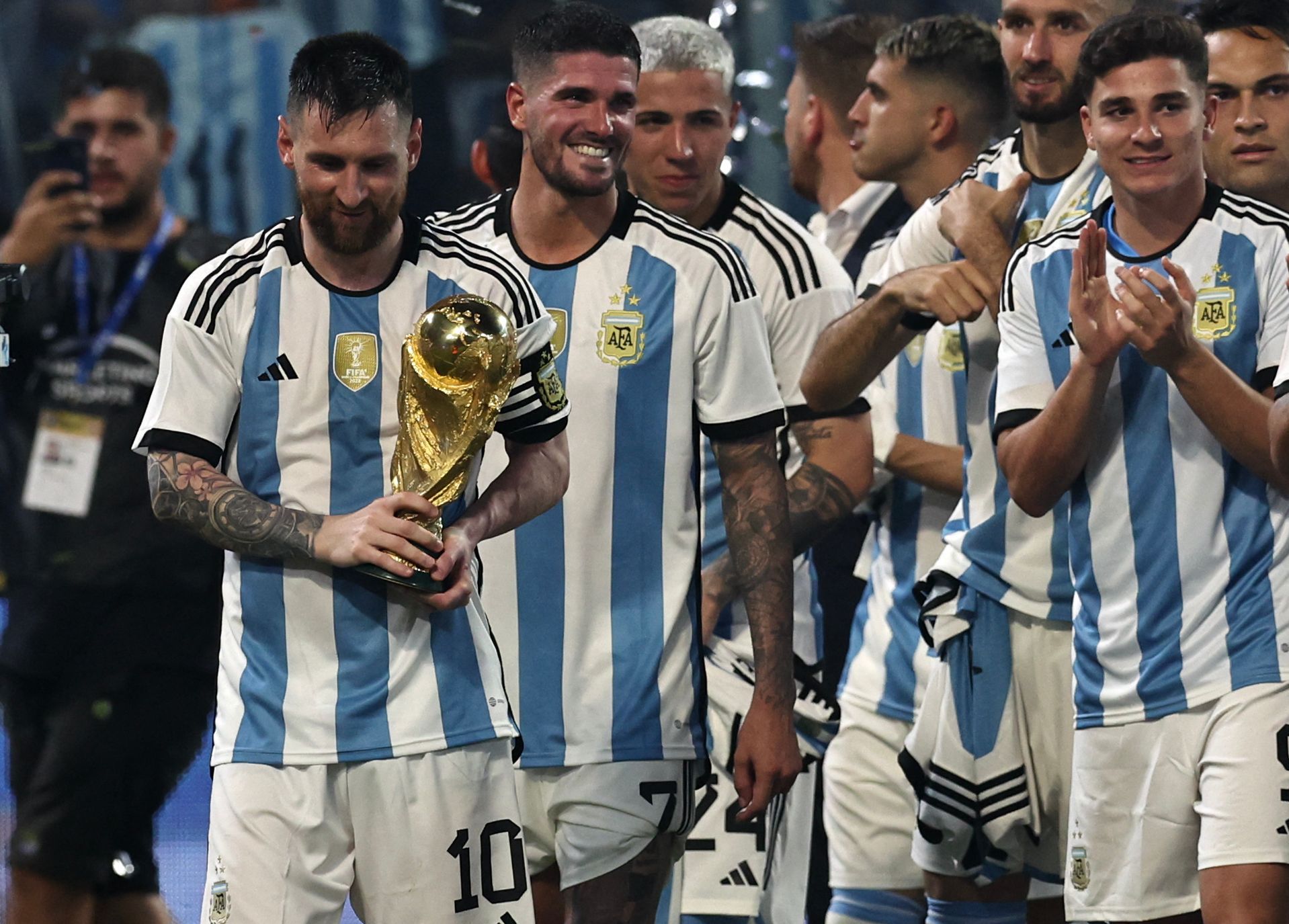 Leo Messi sujeta la Copa del Mundo, rodeado de sus compañeros, en el último amistoso contra Argentina.