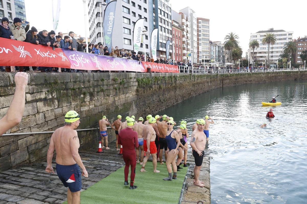 La travesía a nado de Navidad en Gijón congrega un año más a decenas de participantes (en imágenes)