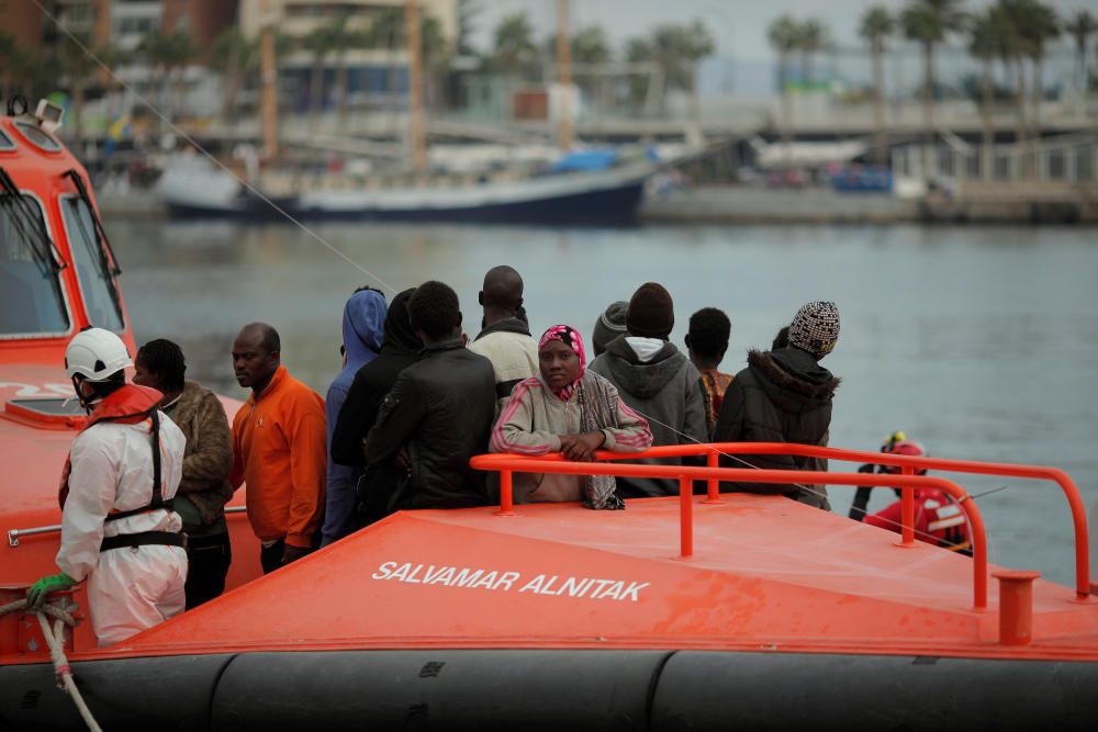 Migrants stand on a rescue boat upon arriving at ...