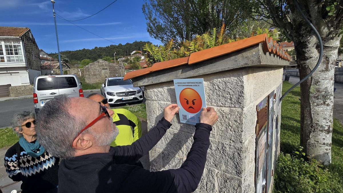 Una acción de Augas Limpas colocando carteles por los vertidos.